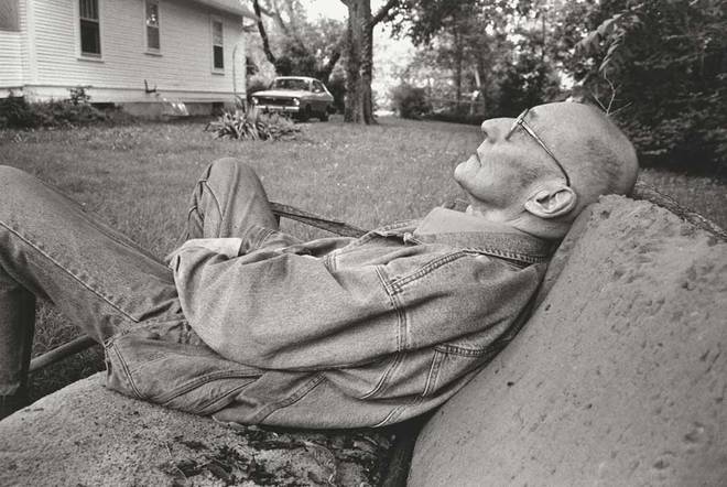 W. S. Burroughs at rest in the sideyard of his house looking at the sky, empty timeless Lawrence Kansas May 28, 1991. But "the car dates it" he noticed when he saw this snapshot.
1991<br>
gelatin silver print, printed 1991–1997<br>
image: 22.2 x 33 cm (8 3/4 x 13 in)