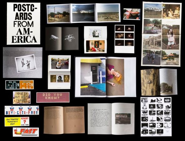 Postcards From America is a collection of objects: a book, five bumper stickers, a newspaper, two fold-outs, three cards, a poster and five zines.