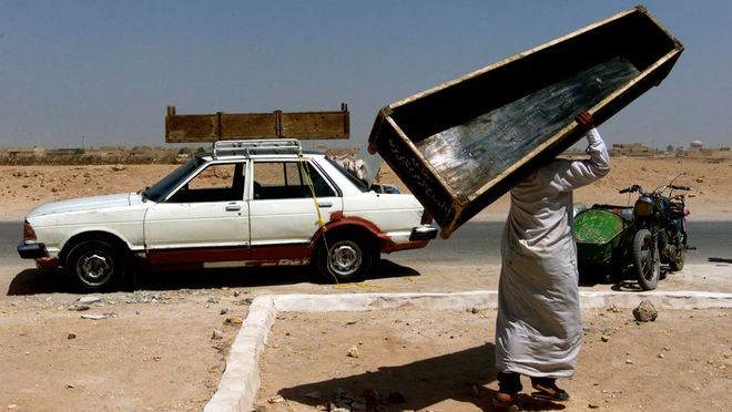 Жоао Сильва / The New York Times. Мужчина идет по улице после похорон матери и дочери, которые погибли во время взрыва в городе Ан-Наджаф, Ирак, 2003 г.