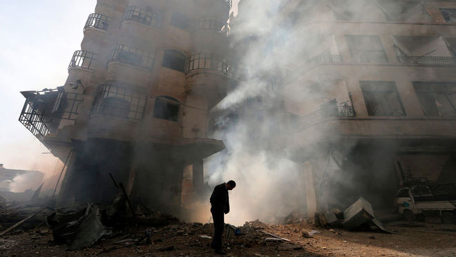 Горан Томашевич / Reuters. Мужчина на одной из улиц в пригороде Дамаска после воздушных атак, январь, 2013 г.